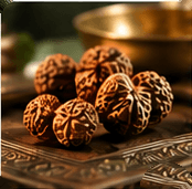 Rudraksha beads on an engraved brass tray, a brass bowl behind
